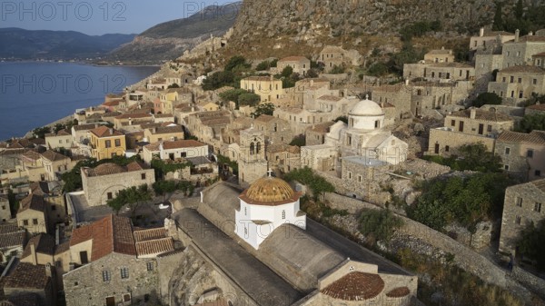 Drone view, Holy Church of the Virgin Mary Myrtidiotissa (or Critikias), aerial view of a village with a domed roof surrounded by coastal landscape, Monemvasia, Monemvassia, Malvasy, Byzantine small town, rocky island, fortress, Laconia, Peloponnese, peninsula, Greece