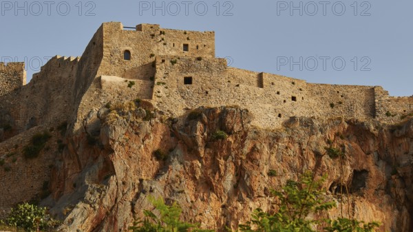 Historic castle wall on rocky cliff under clear sky, Monemvasia, Monemvassia, Malvasy, Byzantine small town, rocky island, fortress, Laconia, Peloponnese, peninsula, Greece