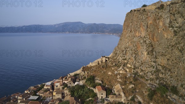 Drone shot, coastal landscape with cliffs, traditional village and mountain view, Monemvasia, Monemvassia, Malvasy, Byzantine small town, rocky island, fortress, Laconia, Peloponnese, peninsula, Greece