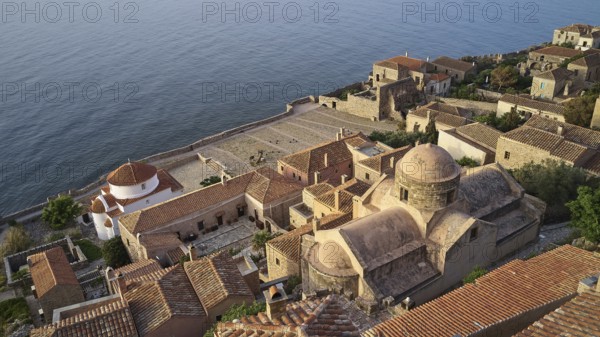 Drone shot, Holy Church of the Virgin Mary Chrysaphitissa, historic town with tiled roofs and church situated by the sea, Monemvasia, Monemvassia, Malvasy, Byzantine small town, rocky island, fortress, Laconia, Peloponnese, peninsula, Greece