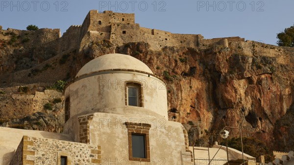 Soft morning light, historic buildings and fortress elements in front of an impressive rock wall, Monemvasia, Monemvassia, Malvasy, Byzantine small town, rocky island, fortress, Laconia, Peloponnese, peninsula, Greece