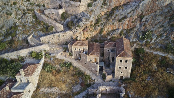 Drone view, aerial view of an ancient fortress with stone houses and vegetation on rocky terrain, Monemvasia, Monemvassia, Malvasy, small Byzantine town, rocky island, fortress, Laconia, Peloponnese, peninsula, Greece