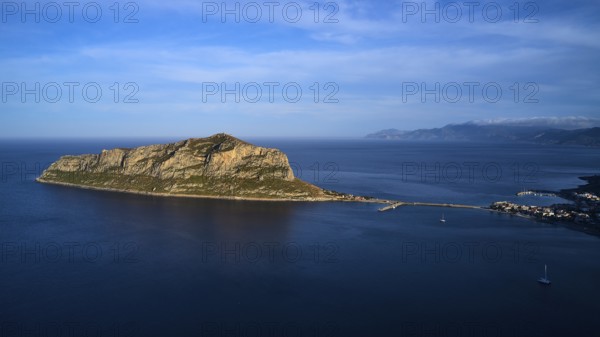 Drone shot, island in the sea, connected by bridge, mountains and sky in the background, Monemvasia, Monemvassia, Malvasy, small Byzantine town, rocky island, fortress, Laconia, Peloponnese, peninsula, Greece