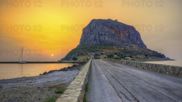 HDR road leads to an imposing mountain by the sea in the soft light of sunrise, Monemvasia, Monemvassia, Malvasy, small Byzantine town, rocky island, fortress, Laconia, Peloponnese, peninsula, Greece