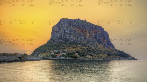 HDR, impressive seaside rock in warm sunrise light, calm water surface, Monemvasia, Monemvassia, Malvasy, small Byzantine town, rocky island, fortress, Laconia, Peloponnese, peninsula, Greece