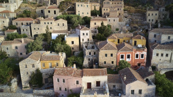Drone shot, view of a colorful old town with densely packed houses and lush gardens, Monemvasia, Monemvassia, Malvasy, small Byzantine town, rocky island, fortress, Laconia, Peloponnese, peninsula, Greece