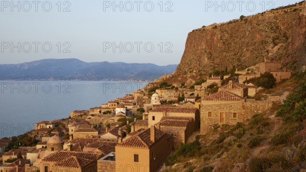Soft morning light, traditional Mediterranean buildings on a rock overlooking the coastline in evening light, Monemvasia, Monemvassia, Malvasy, Byzantine small town, rocky island, fortress, Laconia, Peloponnese, peninsula, Greece