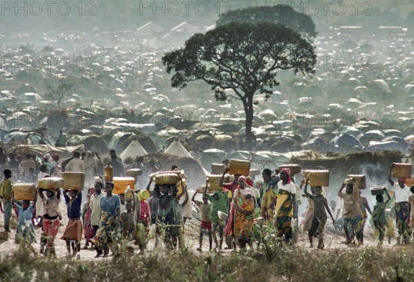 TZA Tanzania scene in the Benaco Camp refugee camp, to which up to 500, 000 Rwandan Tutsis fled the genocide in their country. Refugees fetching water. TZA Tanzania Scene at the Benaco Camp, where an estimate of 500, 000 Rwandan Tutsi refugees fled the genocide in their country. Refugees carry water and supplies