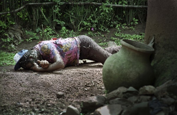 RWA Rwanda Kigali A dead Tutsi lies on the edge of a house on the outskirts of the Rwandan capital. The genocide in Rwanda claimed the lives of 800, 000 Tutsi within 100 days. RWA Rwanda Kigali The body of a dead Tutsi lies in a backyard of a house in the suburbs of Kigali. The Body Is Occupied by Flies