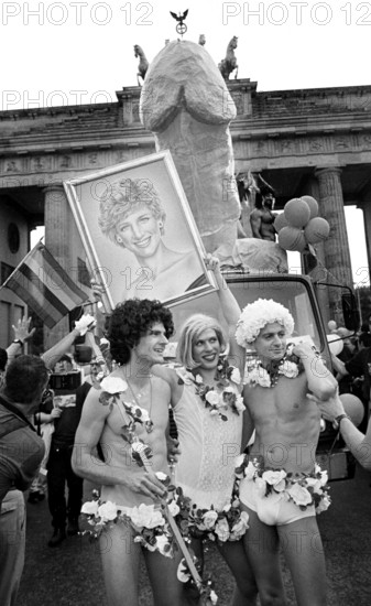 Berlin, DEU, 08.08.1998 -- Giant phallus in front of the Brandenburg Gate. Three participants in the Christopher Street Day Parade wear a portrait of Princess Diana. -- © Karsten Thielker