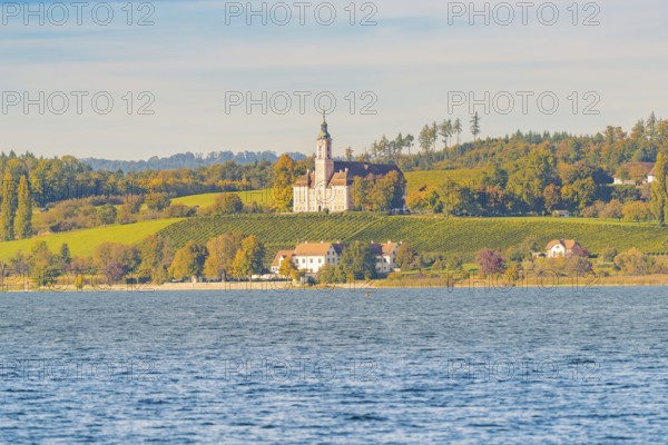 A church on a hill above autumn vineyards and a lake, surrounded by picturesque landscapes and trees, Birnau, Lake Constance, Germany