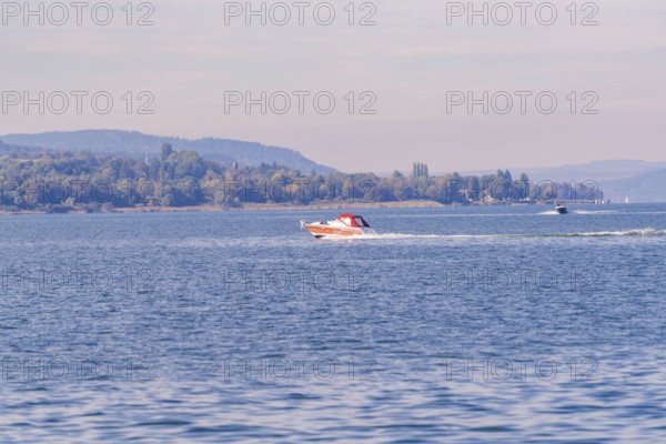 Two motorboats race across the water surface of a lake in a vast landscape, boat trip, Lake Constance, Germany