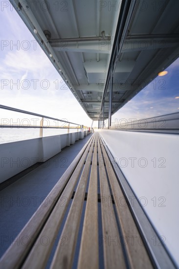 Long ship deck with wooden bench, looking out to sea, with a clear sky above, boat trip, Lake Constance, Germany