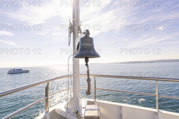 Ship bell aboard a boat on a calm sea under sunny sky, boat trip, Lake Constance, Germany