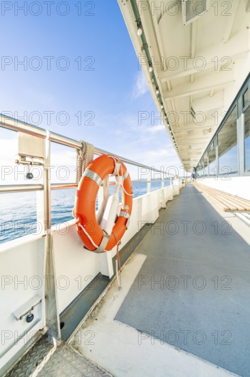 Side view from a ship deck with lifebuoy, calm sea and sunny sky, boat trip, Lake Constance, Germany