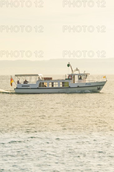 Boat sails towards the horizon on the lake at sunset, boat trip, Lake Constance, Germany