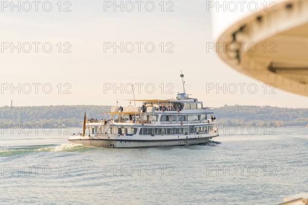 A ship sails away from a shore while part of another ship is visible, Schiff Fahrt, Lake Constance, Germany