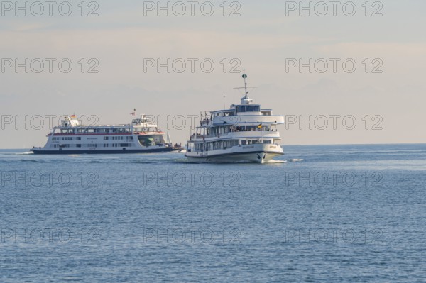 Two large ships sail in the same direction on a calm body of water, Schiff Fahrt, Lake Constance, Germany