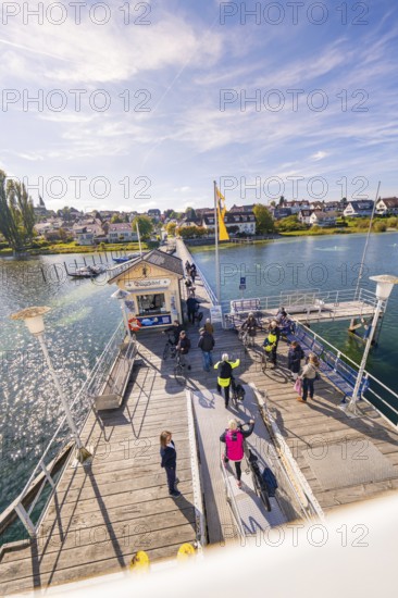 People at a pier in sunny autumn weather, boat trip, Lake Constance, Germany