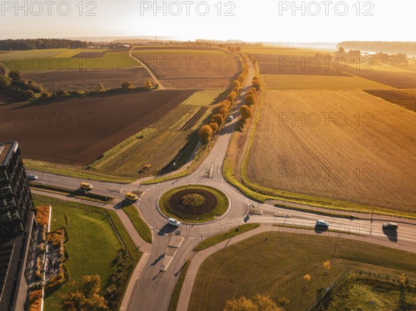 Extensive landscape with roundabout and fields, colored in autumn at sunset, Nagold, Black Forest, Germany