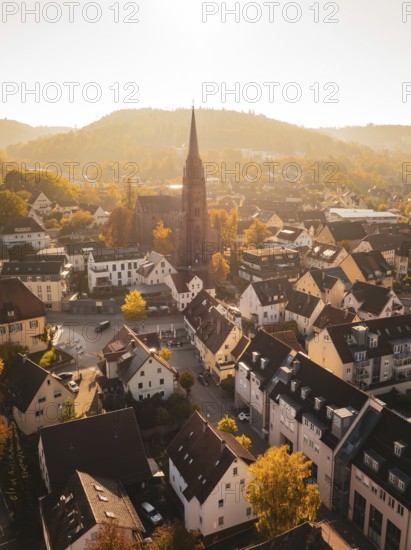 A village with a central church surrounded by autumn leaves and rolling countryside, Nagold, Black Forest, Germany