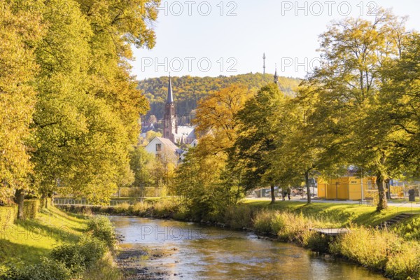 Autumn river landscape with a church and colorful trees in the background, Nagold, Black Forest, Germany