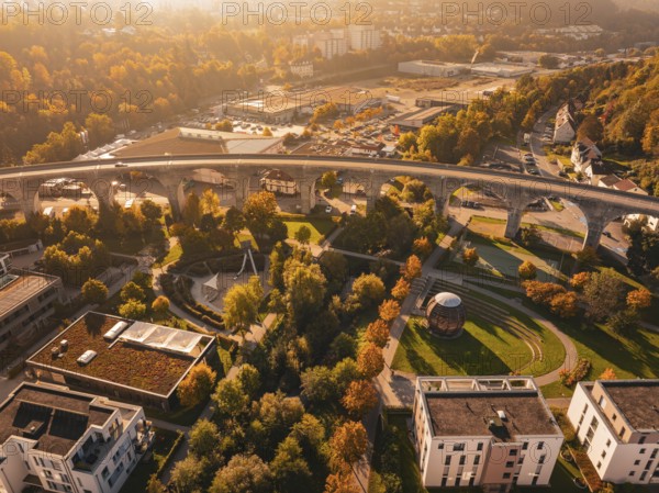 A viaduct within a city, surrounded by autumn-colored nature and modern buildings, Nagold, Black Forest, Germany