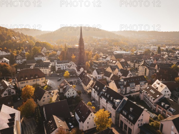 A view of a town with a church in the center, surrounded by autumn-colored trees, Nagold, Black Forest, Germany