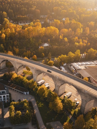A viaduct crosses an area in autumn colors, with houses and surrounding nature, Nagold, Black Forest, Germany