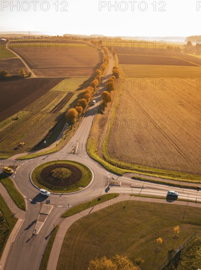 Aerial view of a roundabout surrounded by autumn fields in the evening light, Nagold, Black Forest, Germany