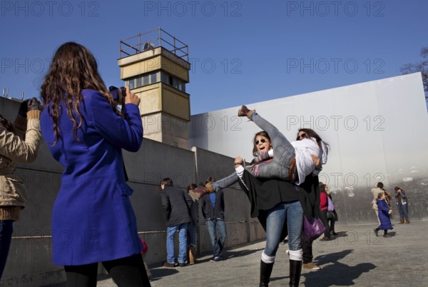 DEU Berlin Spanish tourists pose for photos at the Wall Memorial on Bernauer Straße in Berlin. Germany Berlin Spanish tourists stage pictures at the wall memorial at Bernauer Straße
