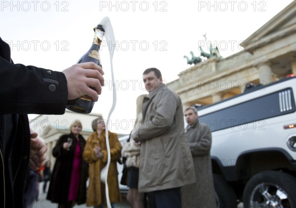 DEU Berlin Wealthy Russian tourists taking a city tour in a stretch limousine stand in front of the Brandenburg Gate. Germany Berlin Russian tourist in front of a stretch limousine at Brandenburg Gate