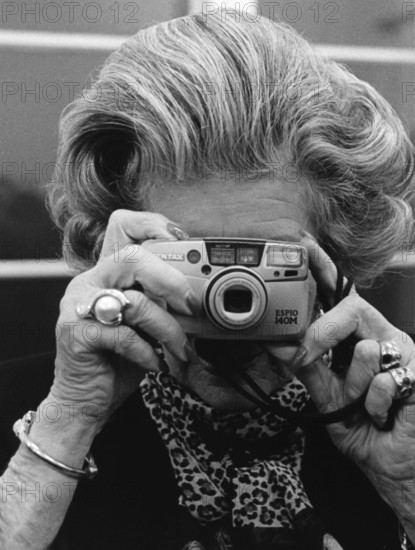 DEU, Germany, Berlin, 22.11.1999. An elderly woman takes pictures during an exhibition opening in Berlin-Mitte