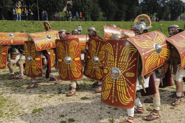 Traditional group Roman soldiers and centurion centurion in tradition of historic ancient Roman battle group foot troop with sword and shield plays military defense turtle formation, Circus Maximus, Rome, Italy