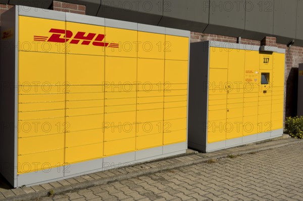 Large DHL packing station in typical yellow color with red logo, Germany