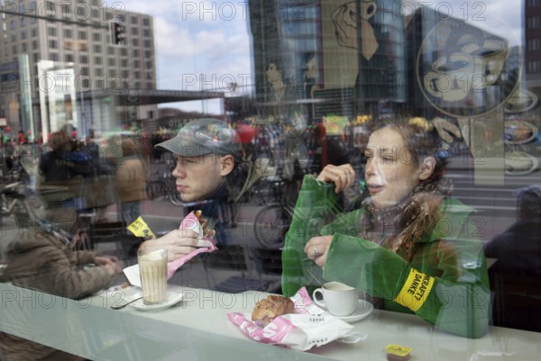 Germany Berlin Anti-nuclear power demonstration in Berlin Mitte. Demonstrators watch the street Deutschland Berlin Protest Rally against Nuclear Power Plants from a cafe. Protesters during a coffee break