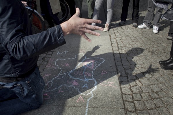 DEU Berlin A tourist guide explains the division of Germany with a circle drawing at Checkpoint Charlie. Germany Berlin A tourist guide explains the separation of Germany after WW II at Checkpoint Charlie
