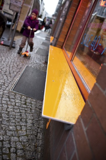 DEU Germany Berlin Orange Bank in front of a shop on a street in Berlin Mitte. Germany Berlin Orange bench in front of a shop in Berlin Mitte