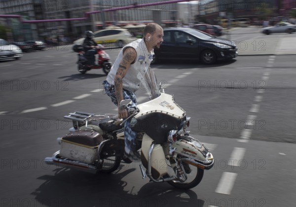 DEU Germany Germany Berlin A cyclist passes Potsdamer Platz on a motorcycle-like bike