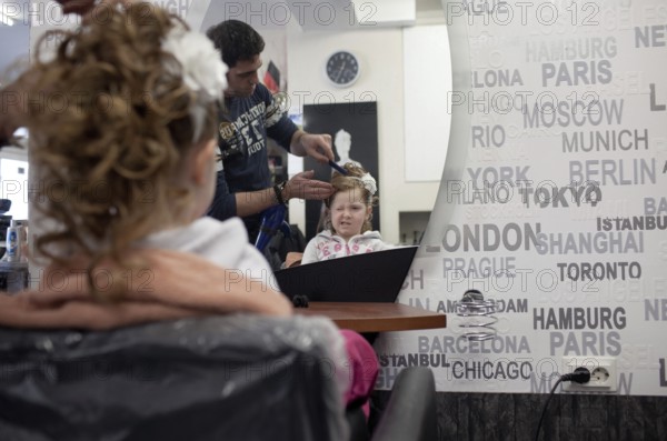 DEU Germany Neuwied A girl in the mirror at the hairdresser. Germany Neuwied A Girl in the Mirror of a Hairdresser Shop