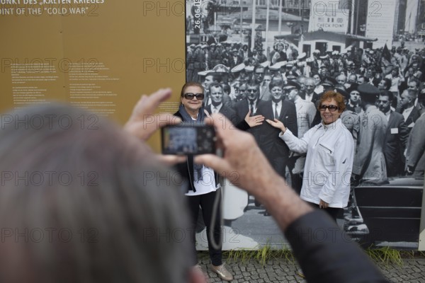 DEU Germany Germany Berlin tourist photographs friends with JF Kennedy and Willy Brandt at Checkpoint Charlie