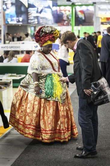 DEU Germany Germany Berlin International Tourism Exchange ITB. A visitor looks at the traditional costume of a Brazilian woman