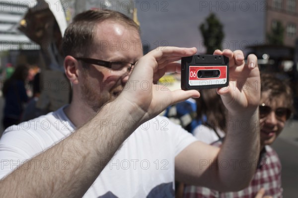 DEU Germany Germany Berlin tourist takes pictures with dummy cassette tape at Checkpoint Charlie