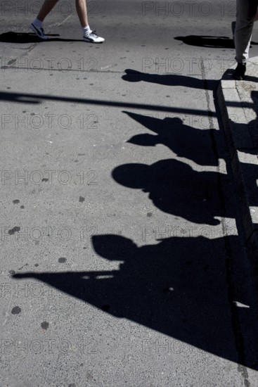 DEU Germany Germany Berlin tourists at Checkpoint Charlie. Shadows of extras disguised as soldiers and their flags