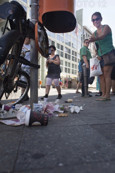 DEU Germany Germany Berlin tourist points to defective trash can at Checkpoint Charlie