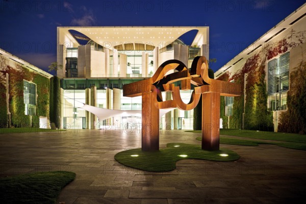 Illuminated Federal Chancellery in the evening with the sculpture entitled Berlin by Eduardo Chillida, Government District, Berlin-Mitte, Berlin, Germany