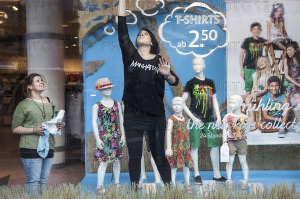 DEU Germany Germany Berlin employees clean a shop window in which the spring collection is on display