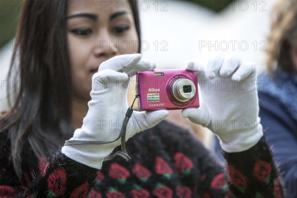 DEU Germany Germany Berlin HZB summer party at the Wannsee site. Woman wearing white gloves taking pictures with a digital viewfinder camera