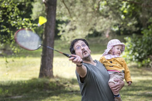 DEU Germany Germany Berlin HZB summer party at the Wannsee site. Father plays badminton with daughter in his arms