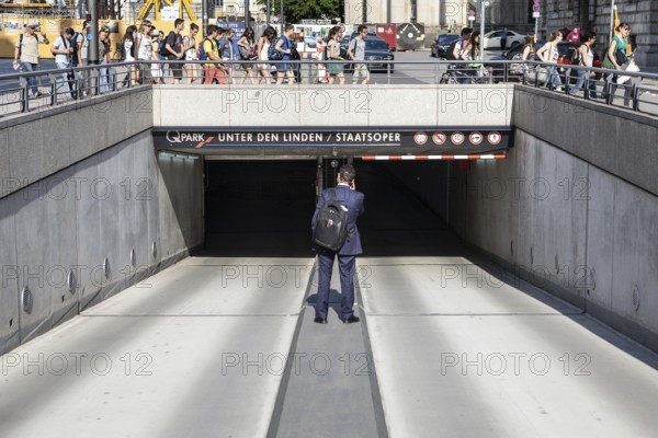 DEU Germany Germany Berlin A man stands in the driveway of a parking garage in Berlin-Mitte while a group of tourists passes